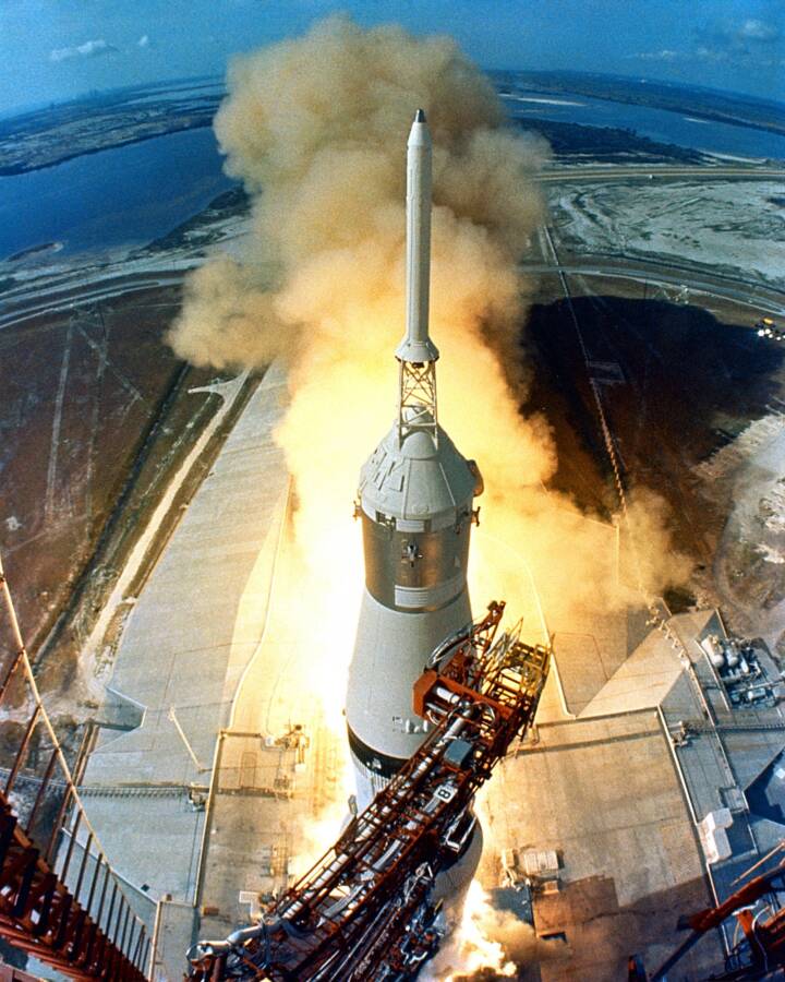 At 9:32 a.m. EDT, the swing arms move away and a plume of flame signals the liftoff of the Apollo 11 Saturn V space vehicle and astronau